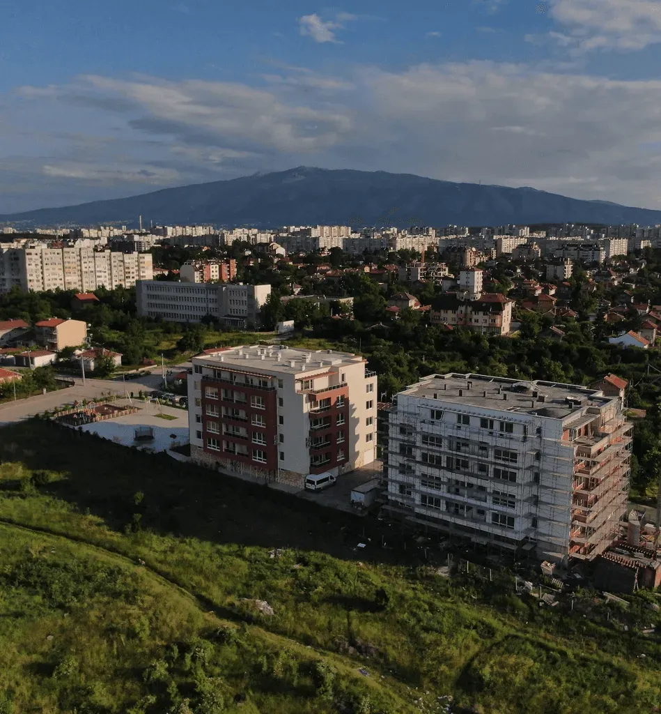 Сградите на Оптима Парк сред зеленина, с планината на заден план